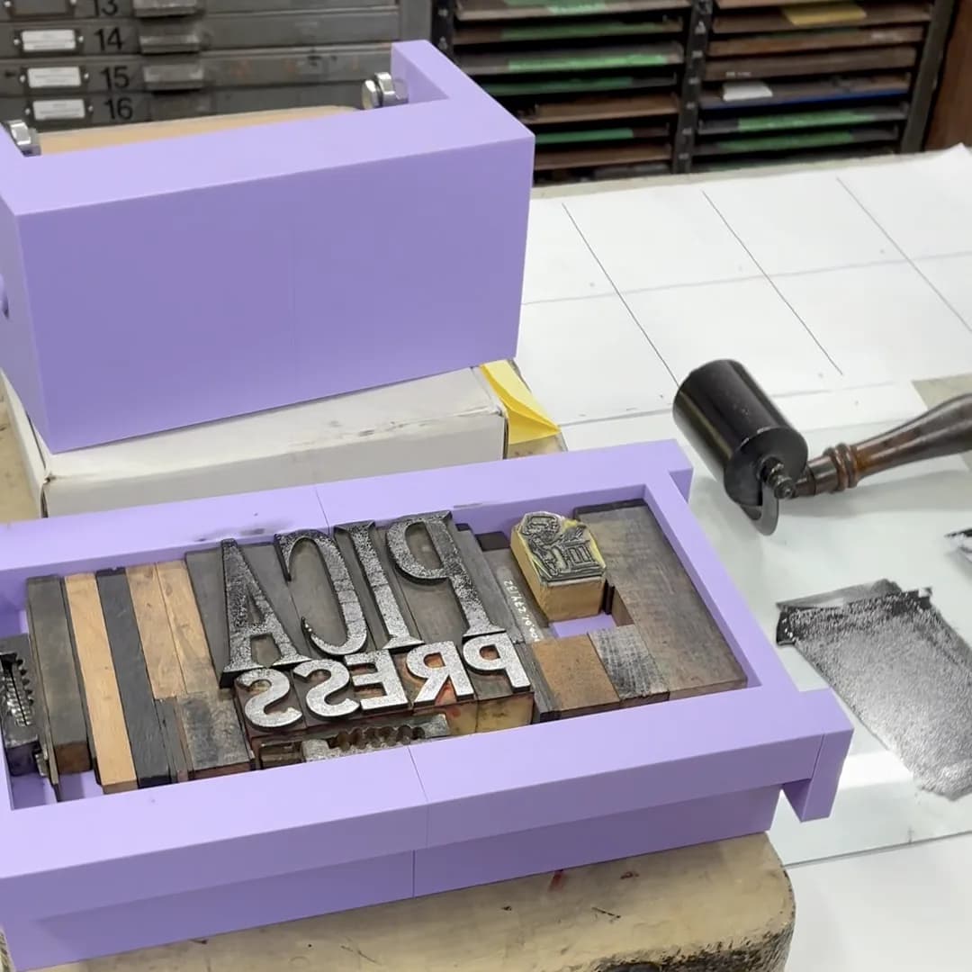 A 3D printed Pica Press on a studio table, locked up with wood type spelling Pica Press